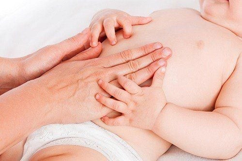 Hình ảnh mẹ đang massage lưng cho bé sơ sinh, giúp bé ngủ ngon và tăng cường tuần hoàn máu.