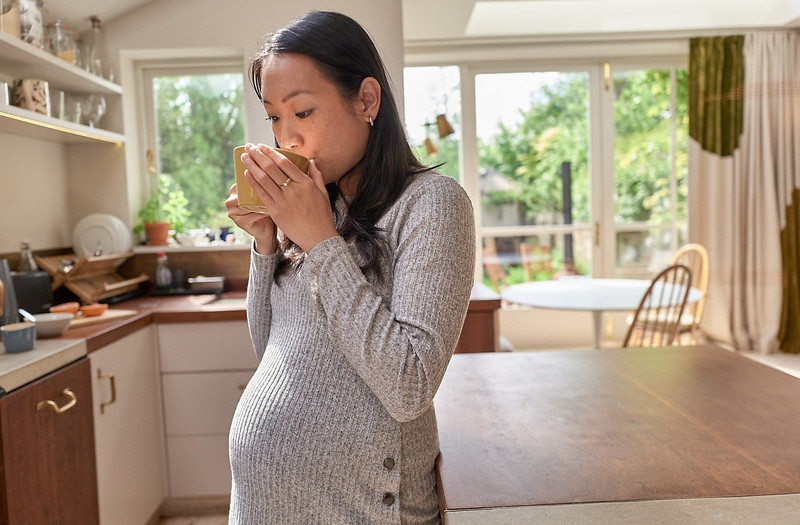 Mẹ bầu hạnh phúc thưởng thức ly sữa bầu thơm ngon, thể hiện sự ưu tiên chọn lựa các loại sữa có vị thanh mát, dễ uống trong thai kỳ.